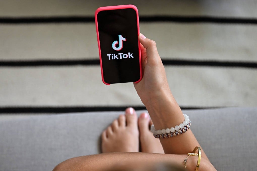 A teenager looks at a smartphone displaying the TikTok logo in Brussels on July 7. Photo: AFP
