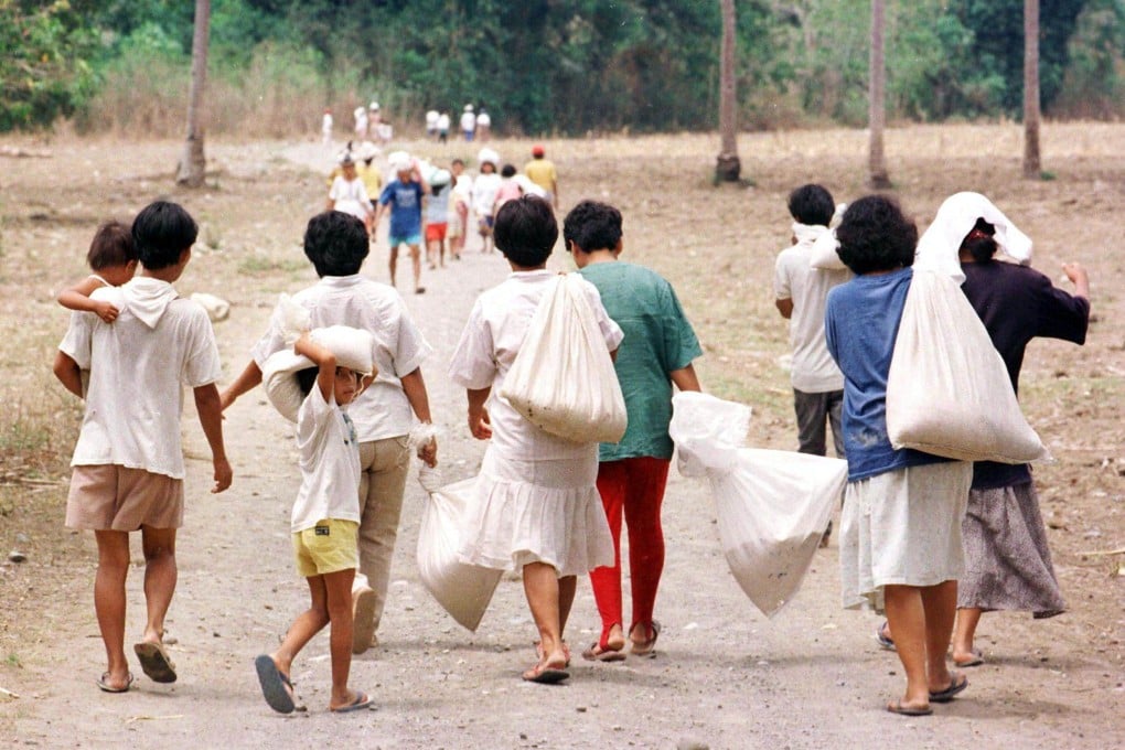 Filipinos affected by severe drought return to their homes carrying government-supplied rice rations in April 1998, when the Philippines previously experienced “super” El Nino conditions. Photo: AFP