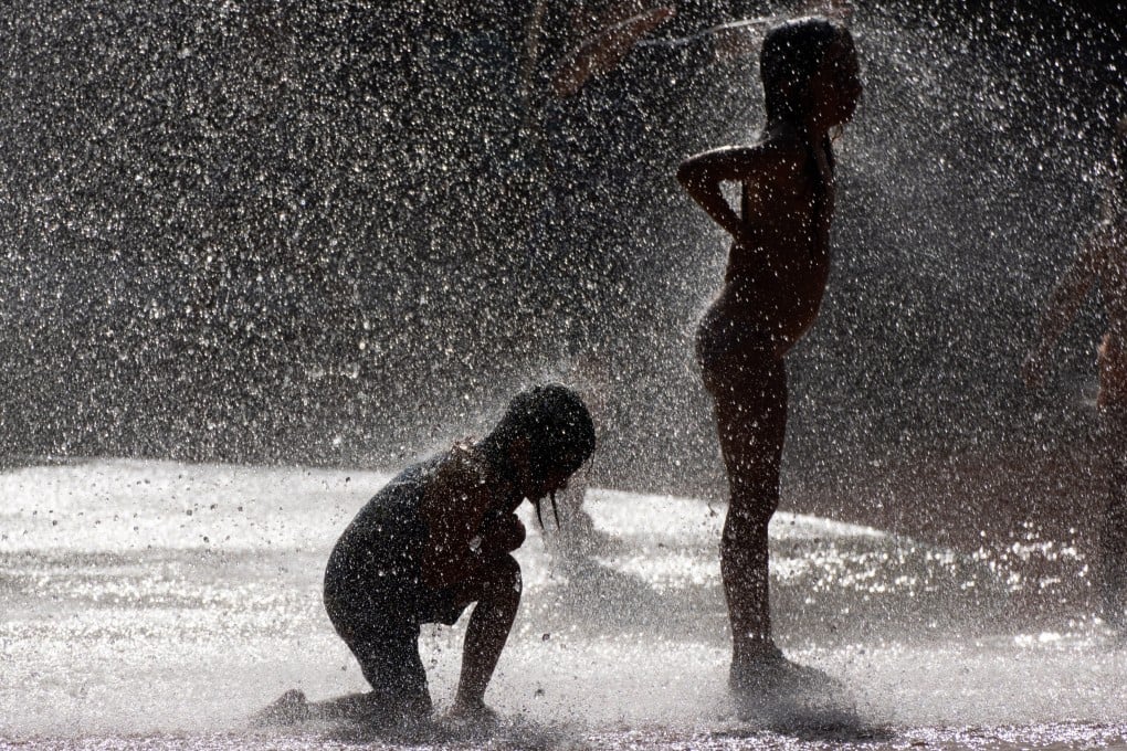 Children cool off at a water playground in a public park in Germany’s Frankfurt am Main on Sunday. Photo: EPA