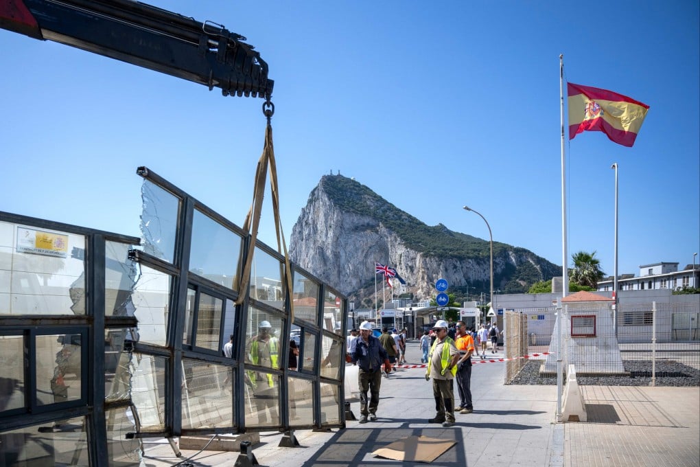Workers dismantle a Spanish border checkpoint in La Linea de la Concepcion with the iconic Rock of Gibraltar in the background. Photo: AP