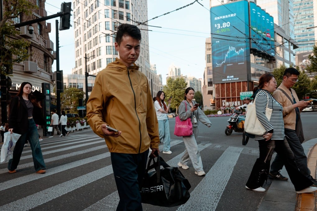 People walk beneath a large screen showing the latest stock exchange and economic data in Shanghai. The tech-centric Star Market 50 Index has experienced a decline of more than 10 per cent in the last two weeks. Photo: EPA