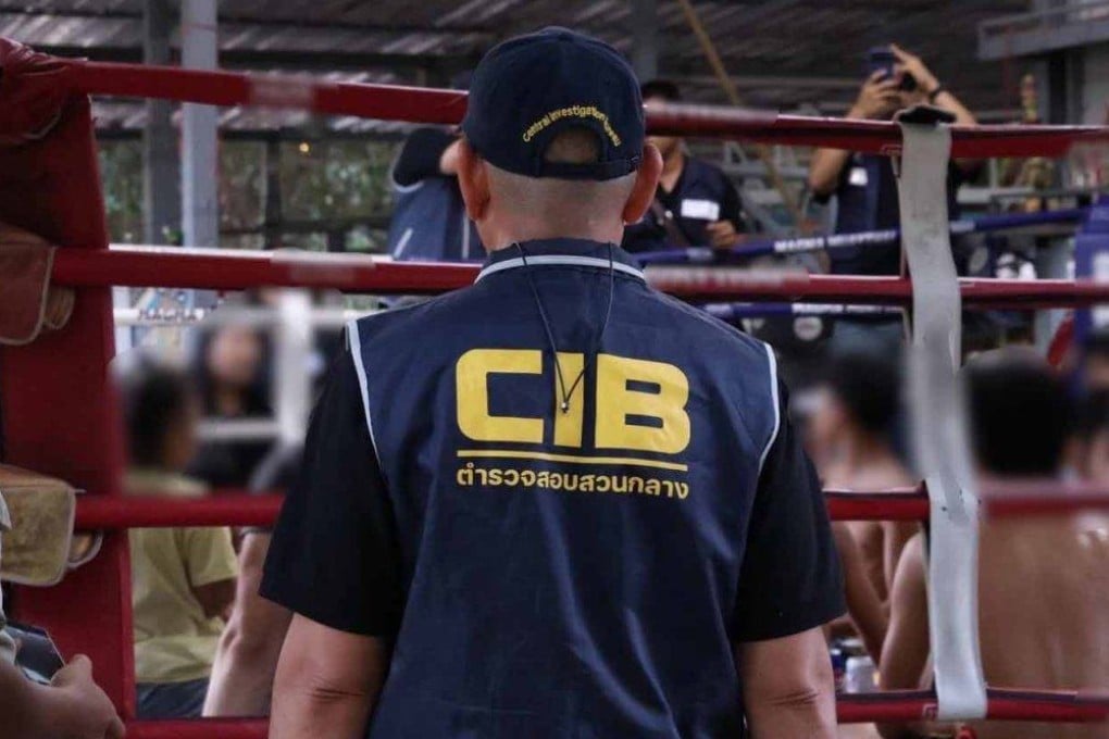 An officer guards the victims after police raid a boxing camp in Rayong province on Tuesday. Photo: Royal Thai Police
