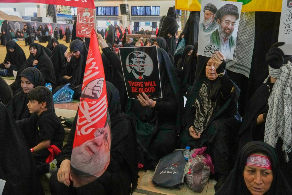 A woman in Tehran holds a poster depicting US President Donald Trump in crosshairs. Photo: AP