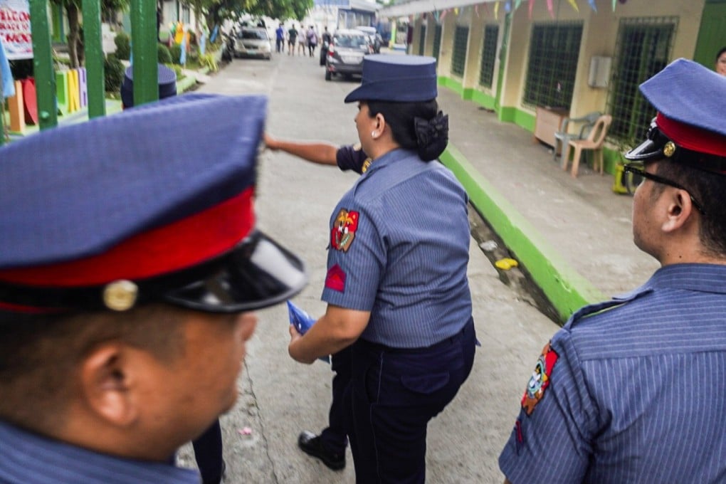 Philippine police officers enter San Jose National High School in Tacloban City after a shooting on June 22. Photo: EPA