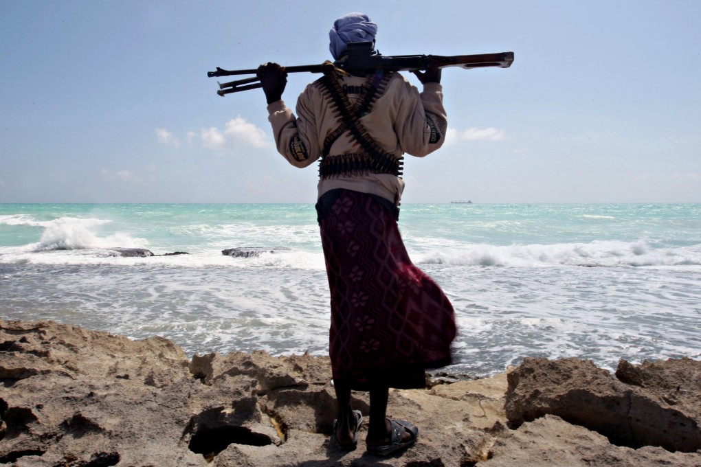An armed Somali pirate watches the coastline of Hobyo town. Photo: AFP