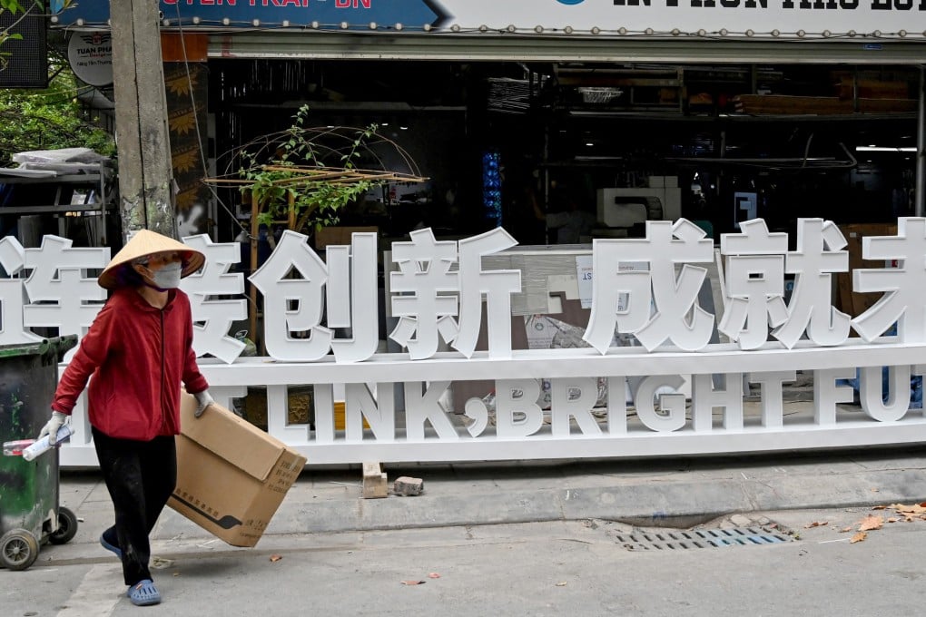 A Vietnamese scrap collector walks past a Chinese-language sign in Bac Ninh province, Vietnam. Photo: AFP
