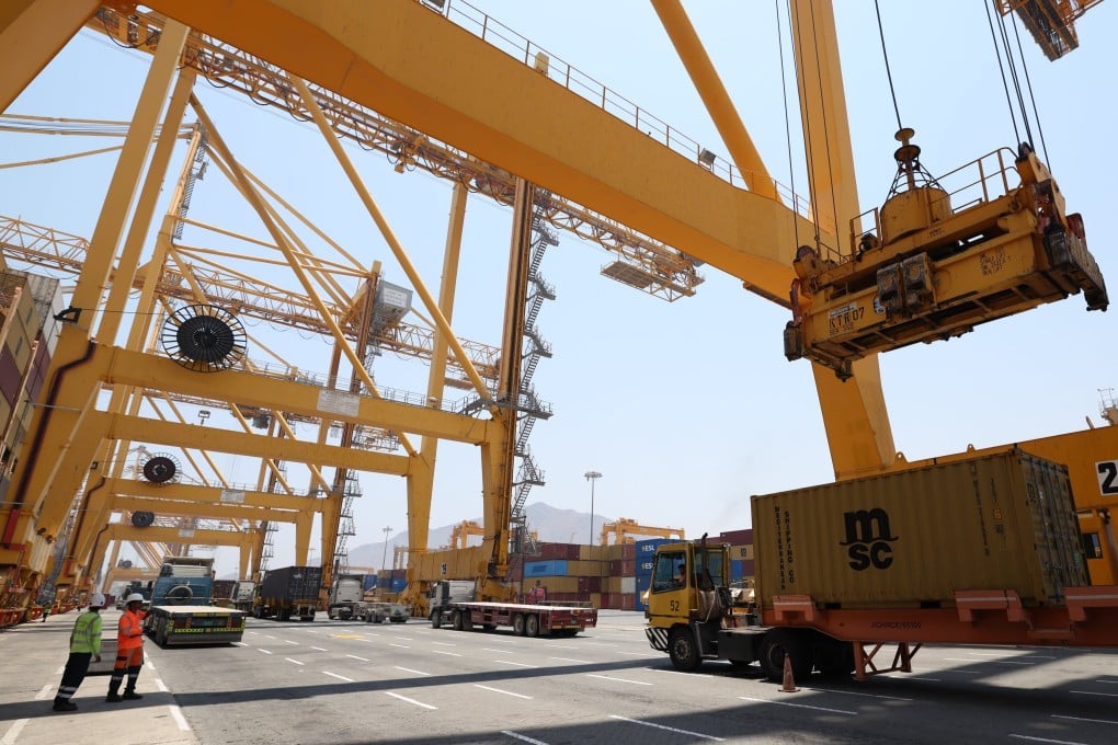 Workers load and unload containers  at Khor Fakkan Port in the United Arab Emirates on July 7. Photo: EPA