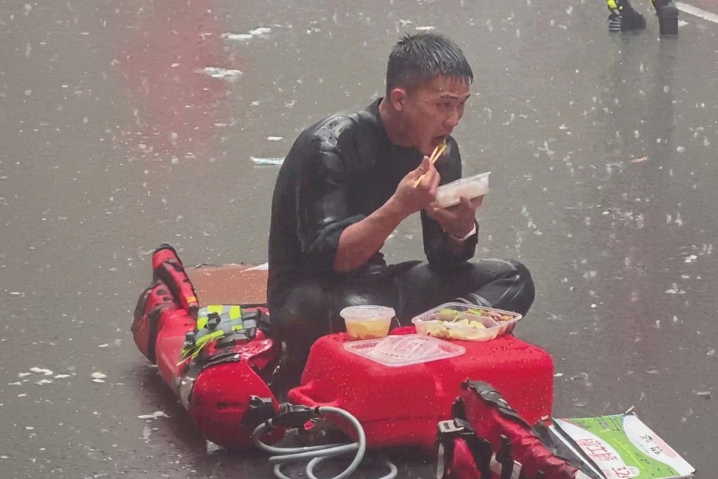 Guangdong firefighter, Liang Huan, grabs a quick meal in the pouring rain during severe flood relief operations in Guangxi. Photo: 163.com