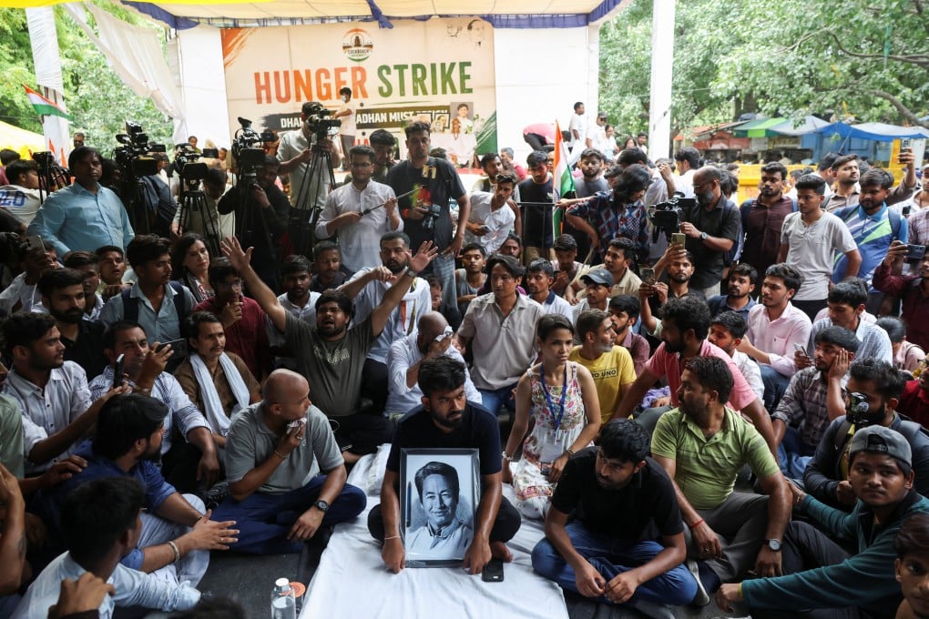 Abhijeet Dipke, head of the Cockroach Janta Party (CJP) holds a picture of Sonam Wangchuk, after Wangchuk was taken to a hospital by authorities during his hunger strike, at Jantar Mantar in New Delhi on Saturday. Photo: Reuters