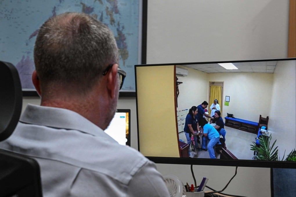 A man watching a footage of a woman being exorcised, in Makati, Metro Manila. Photo: AFP