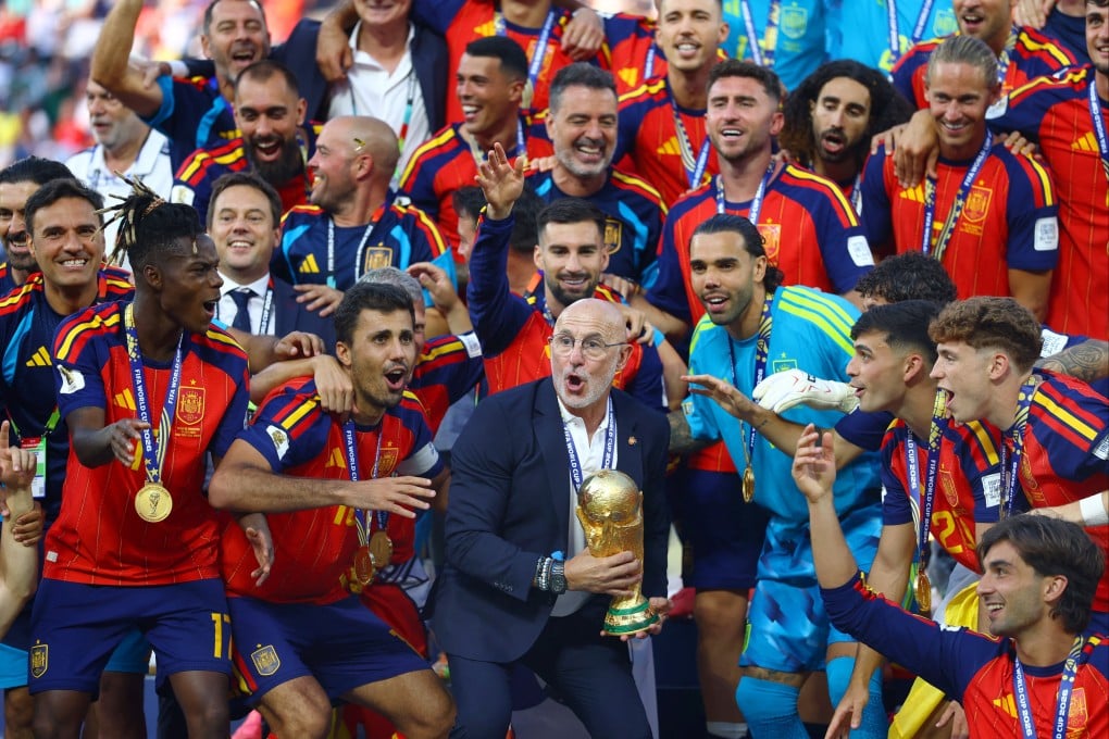 Spain coach Luis De La Fuente lifts the World Cup trophy alongside his players. Photo: Reuters