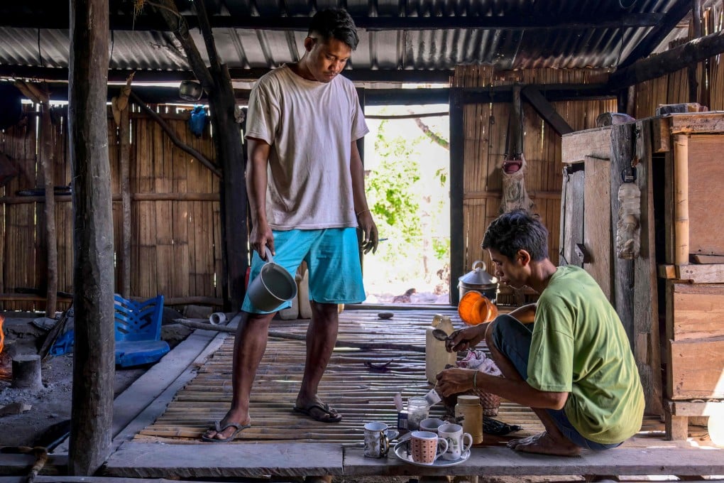 Umbu Ana Rara (left) watches as his “ata”, Kanisius Kanyali Hambarita, prepares drinks at Tanggedu village in East Sumba on June 23. Photo: AFP