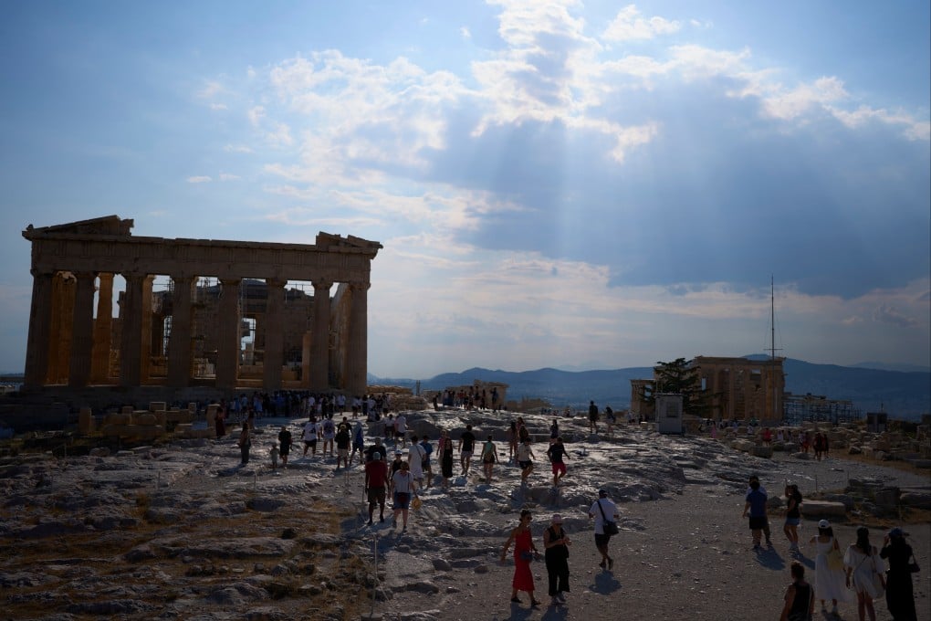 Tourists walk across the Acropolis in Athens on July 2. Photo: AP