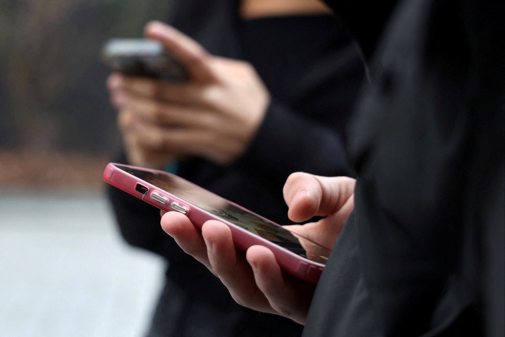 Teenagers look at their mobile phones during an interview about France’s proposed social media ban in Paris on Monday. Photo: Reuters