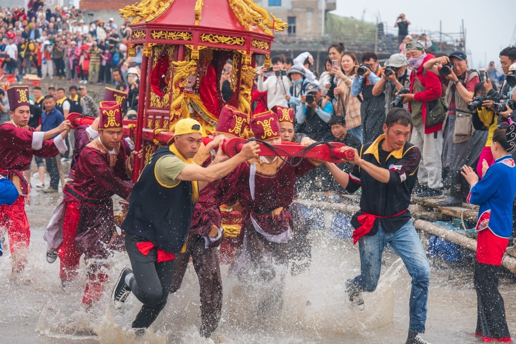 Pilgrims carry a sedan chair holding a statue of Mazu, the sea goddess, during a ceremony in 2023 in Ningde, Fujian province. It is fitting that a modern weather warning system designed to protect lives should carry the name of a guardian long associated with the sea. Photo: VCG via Getty Images