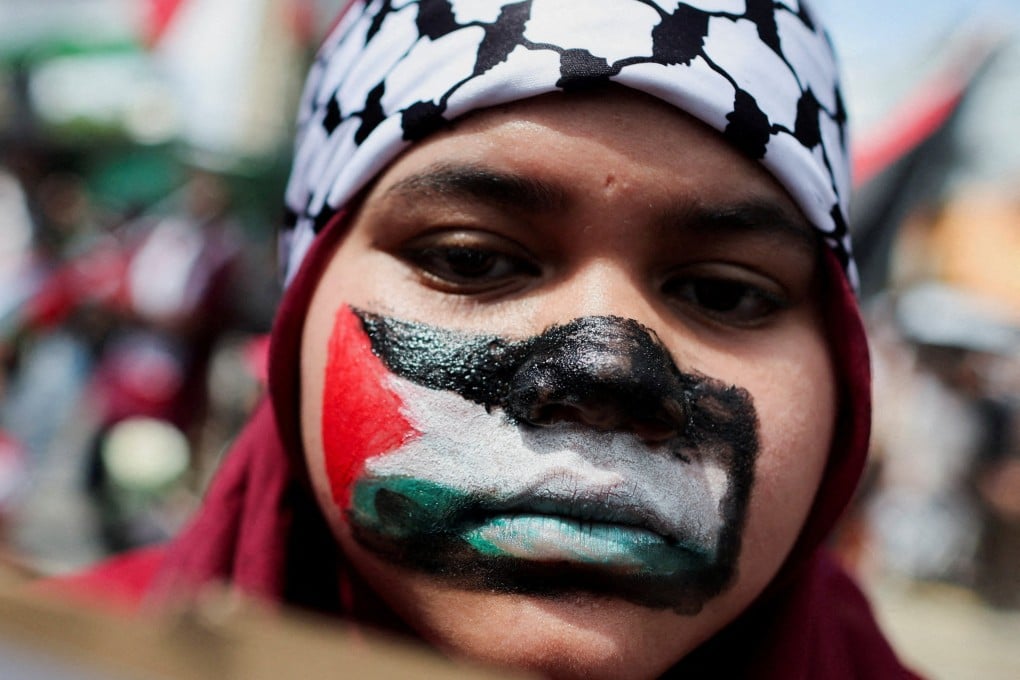 A pro-Palestinian supporter paints her face with the Palestinian flag during a march to the US Embassy in Kuala Lumpur on March 13. Photo: Reuters