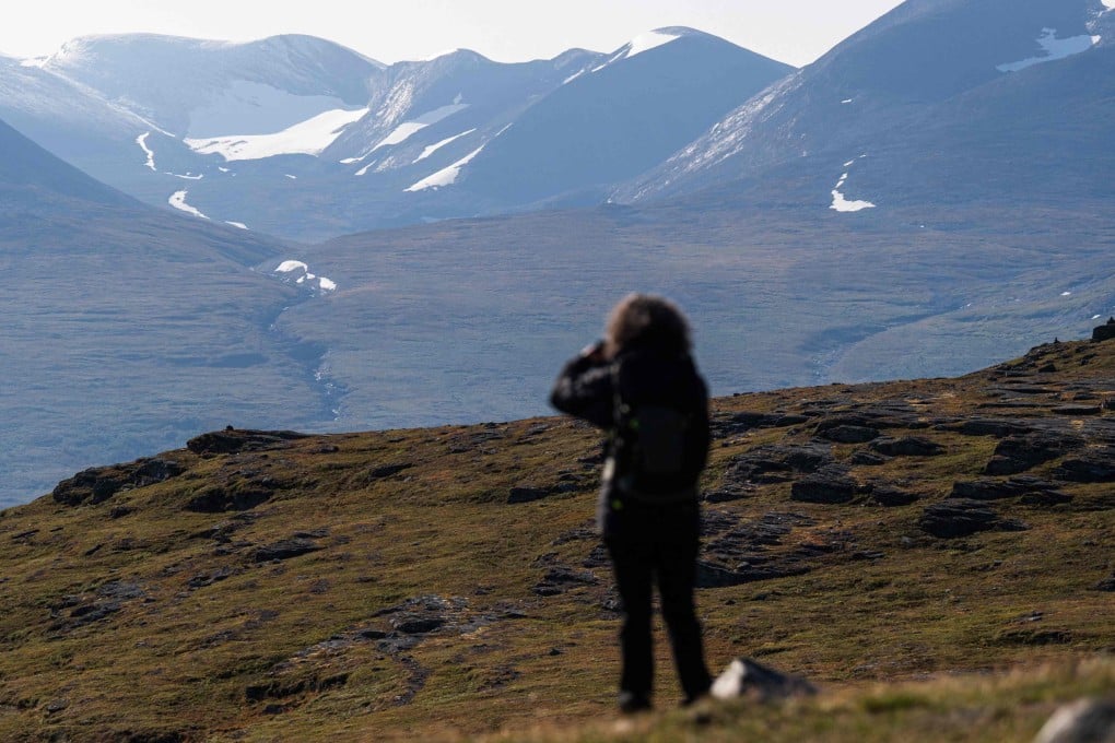 A tourist takes photos of Mount Nuolja, overlooking Abisko in northern Sweden, on August 26, 2021. Photo: AFP