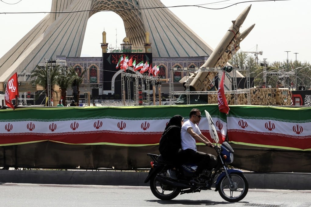 A couple rides past Iranian-made Zolfaghar missiles displayed at Azadi Square in Tehran on Friday. Photo: TNS