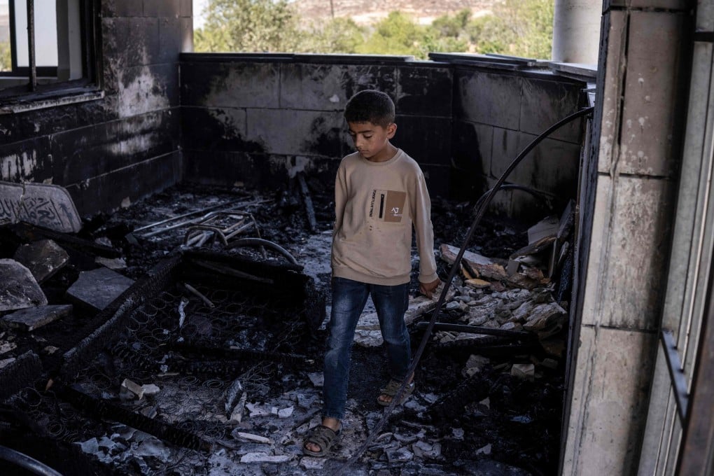 A young Palestinian boy is seen at a mosque allegedly burned by Israeli settlers in the village of Qusra, south of Nablus in the Israeli-occupied West Bank on Sunday. Photo: AFP