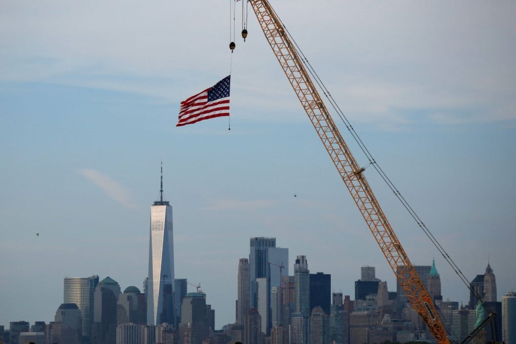 An American Flag hangs from a crane at Port Liberty in Bayonne, New Jersey, on Friday. US President Donald Trump has slapped new tariffs on 60 trading partners. Photo: AFP