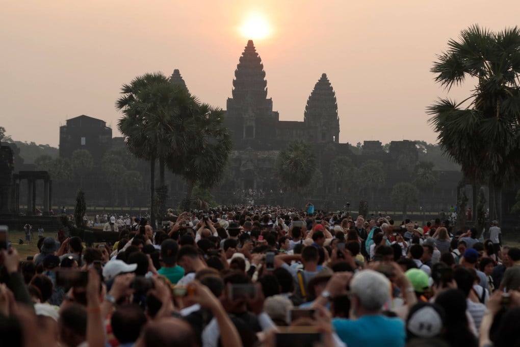 Tourists jostle for a picture of the sunrise over the central stupa of Angkor Wat temple in 2018. Photo: Getty Images/AFP