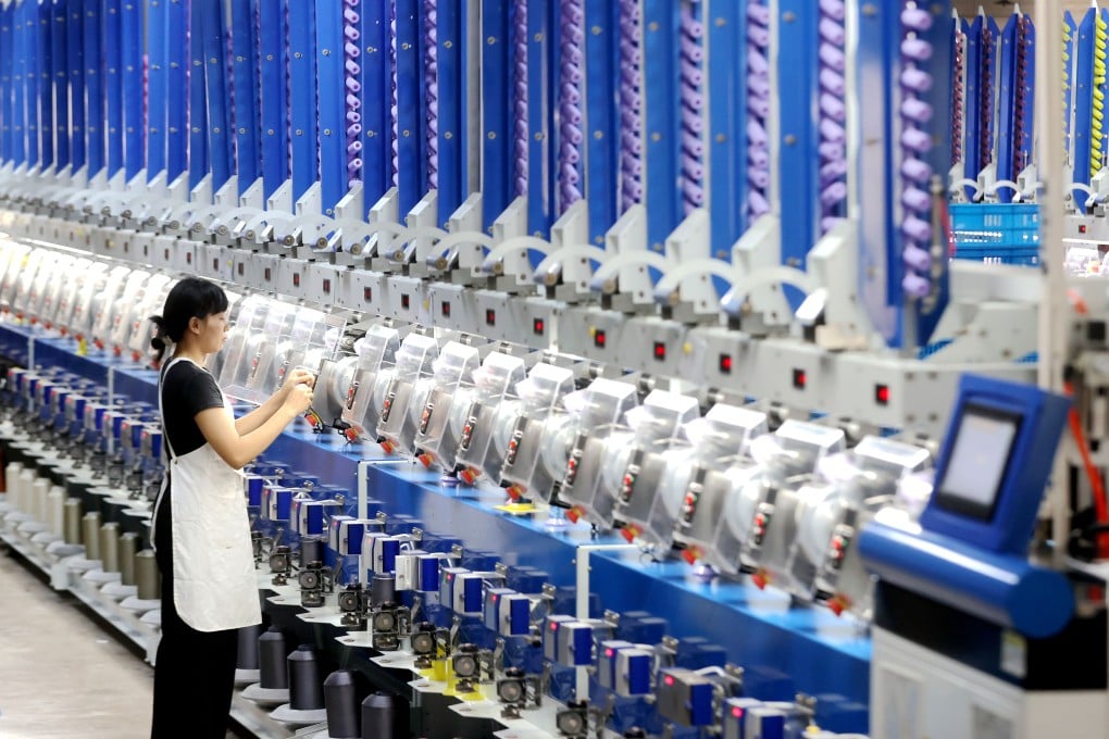 A worker checks automated spool winders at a factory in China’s Zhejiang province last month. A recent poll of private firms in the country found that many are still struggling. Photo: Xinhua