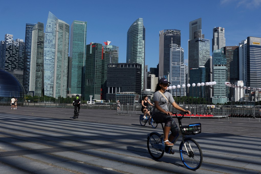 People ride bikes past the skyline of the central business district in Singapore. Singapore detained three teenagers over separate plots to carry out shooting, stabbing and bomb attacks. Photo: Reuters