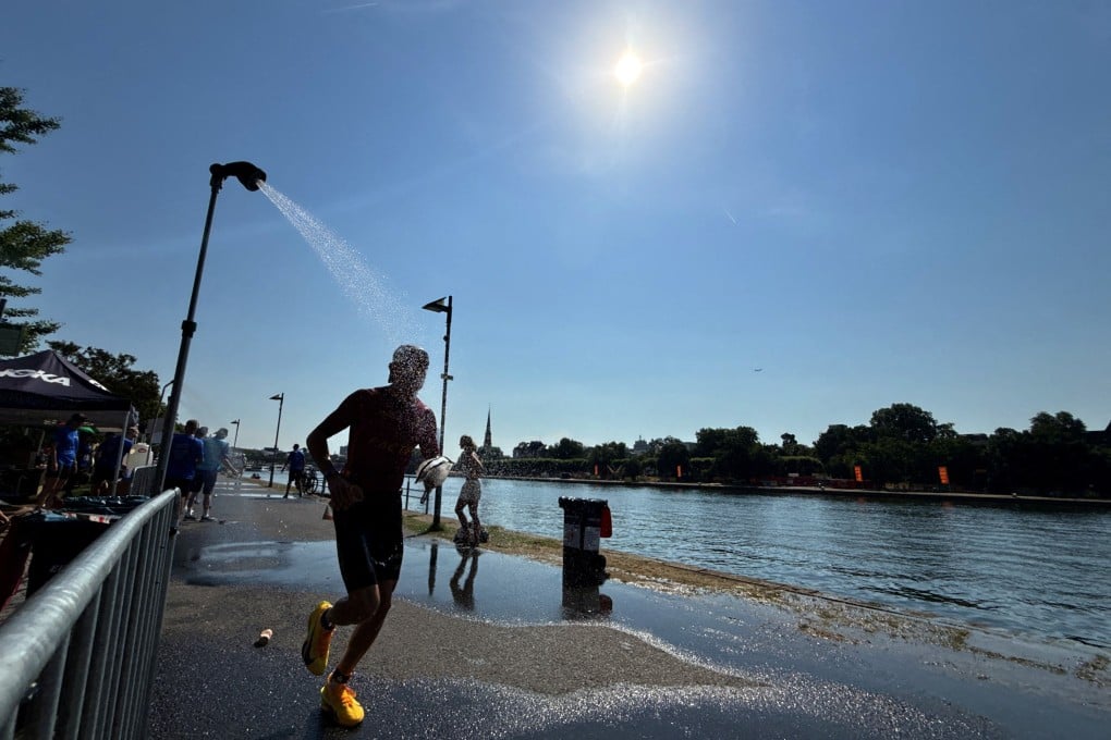 An athlete runs under a shower near the Main River to cool off during an ongoing heatwave in Frankfurt, Germany, on June 28. Photo: Reuters