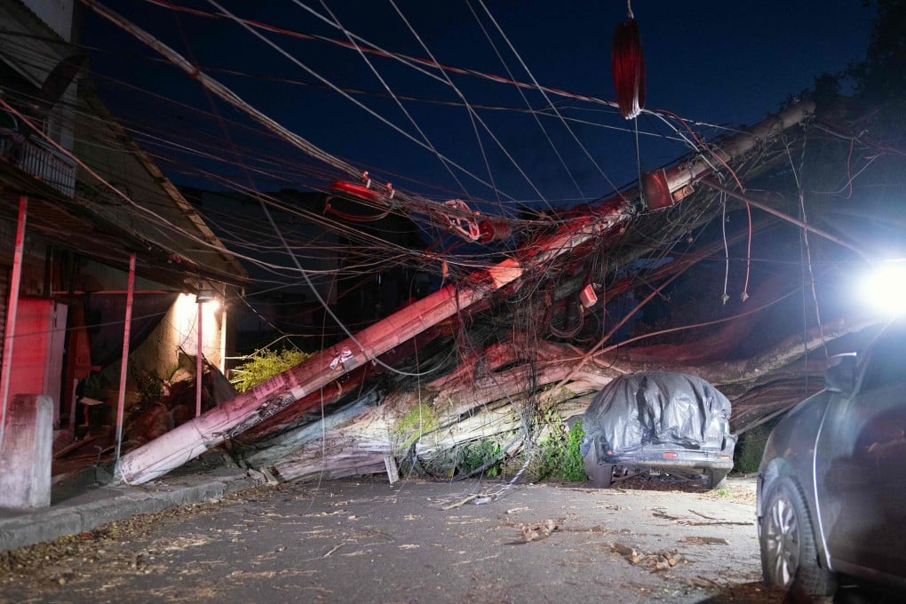 A fallen tree and collapsed utility poles block a residential street after strong wind gusts in Rio de Janeiro, Brazil, on Wednesday. Photo: AFP