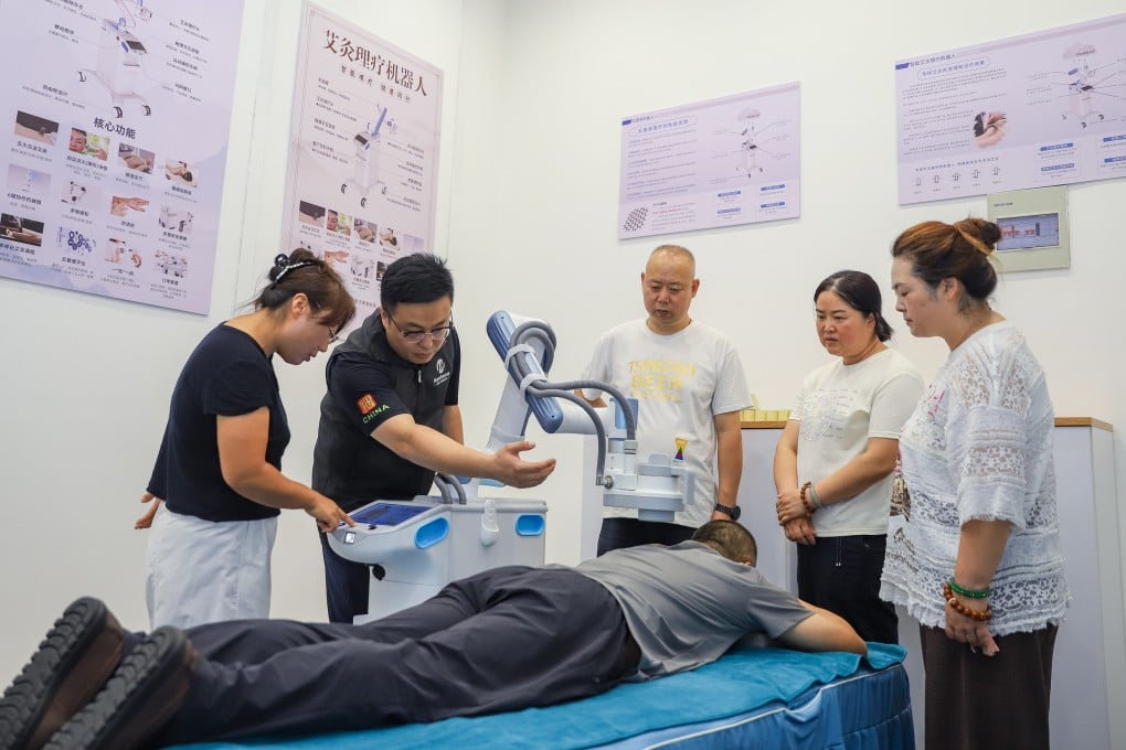 An instructor teaches trainees to operate a therapy robot at a domestic services training centre in Qingdao, Shandong province, on July 21. Photo: Xinhua