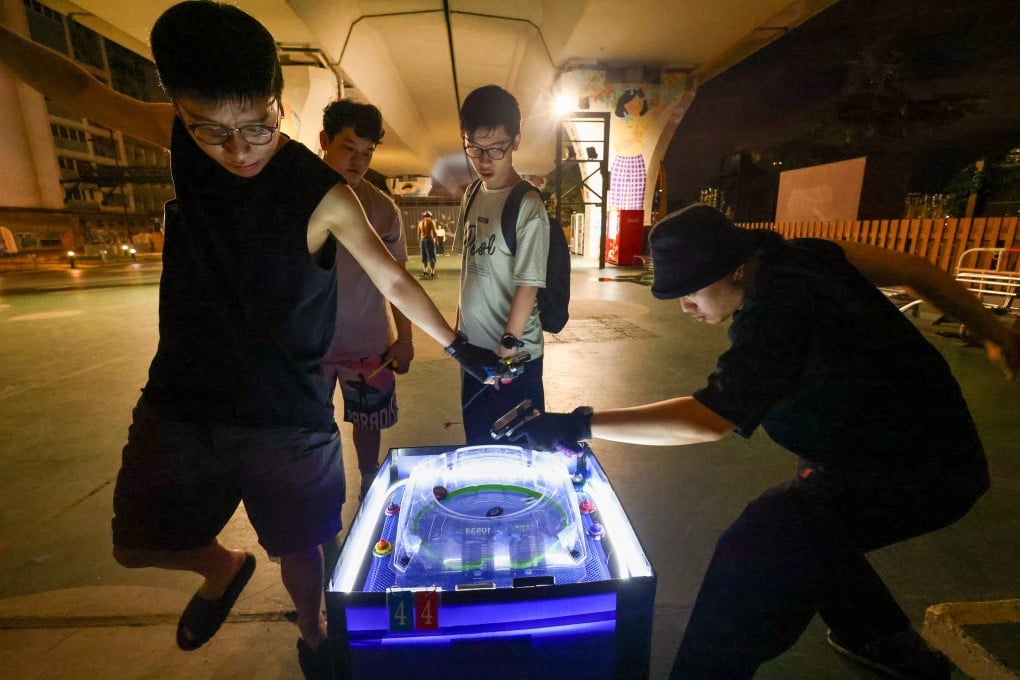 People gather along Kwun Tong Promenade to play with battling spinning tops on May 7. Beyblades have been making a comeback across Hong Kong. Photo: Dickson Lee