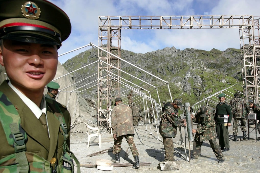 A Chinese soldier stands guard while Indian troops work at the Nathu La Pass in July 2006. Photo: AP