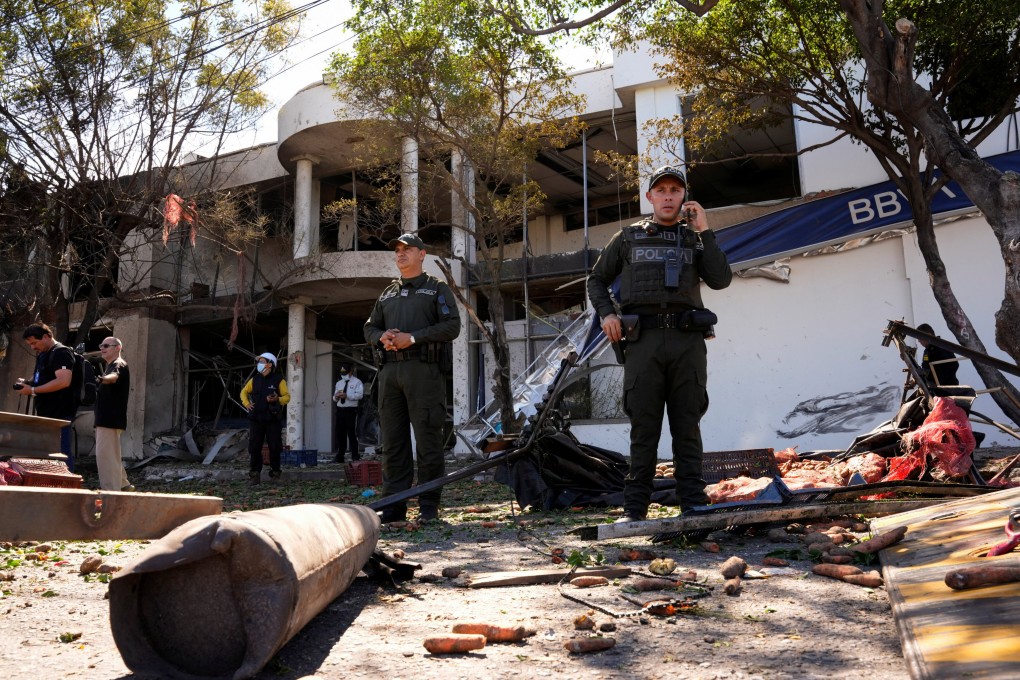 Police officers stand outside a building damaged after a truck packed with explosives detonated next to a police station in Cucuta, Colombia on Saturday. Photo: Photo: Reuters