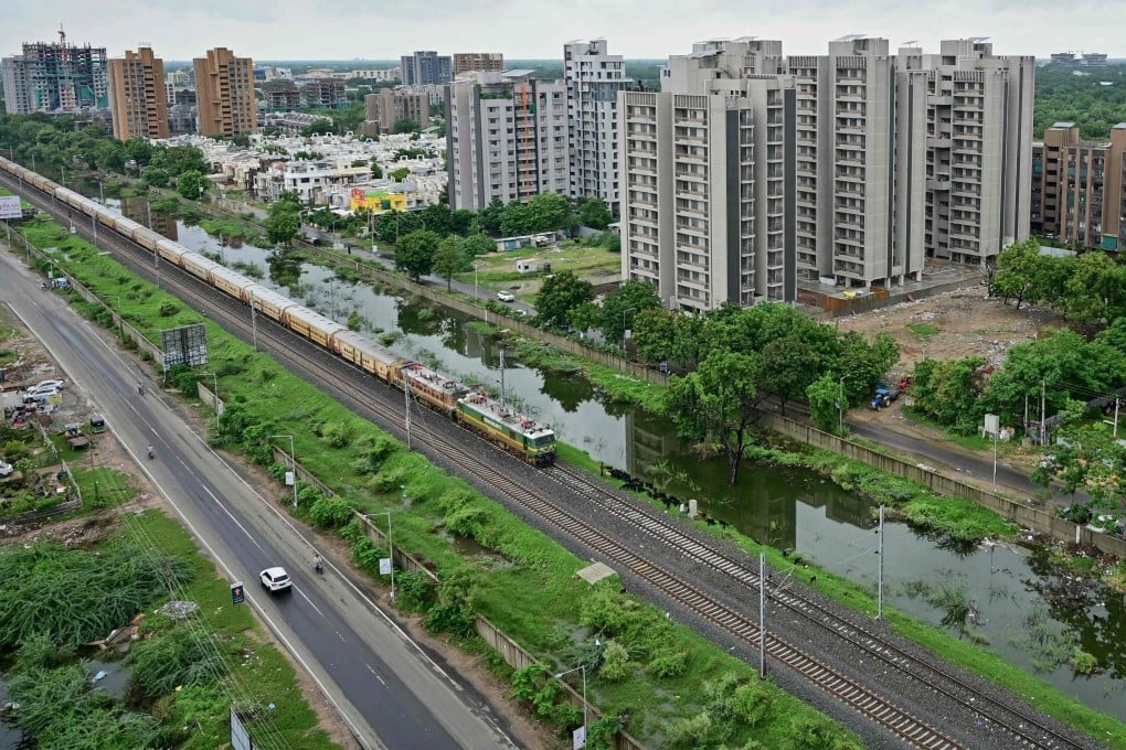 A train runs along a residential neighbourhood as monsoon clouds hover in Ahmedabad in the Indian state of Gujarat on August 1. Photo: AFP