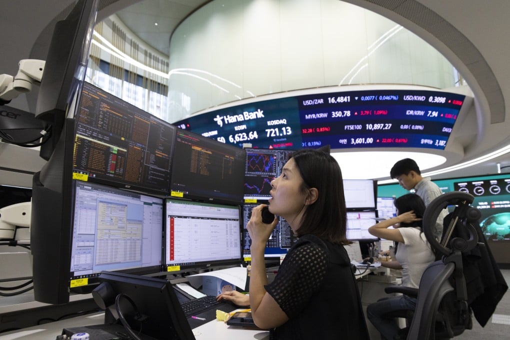 South Korean dealers work in front of monitors at the Hana Bank in Seoul on July 31. Photo: EPA
