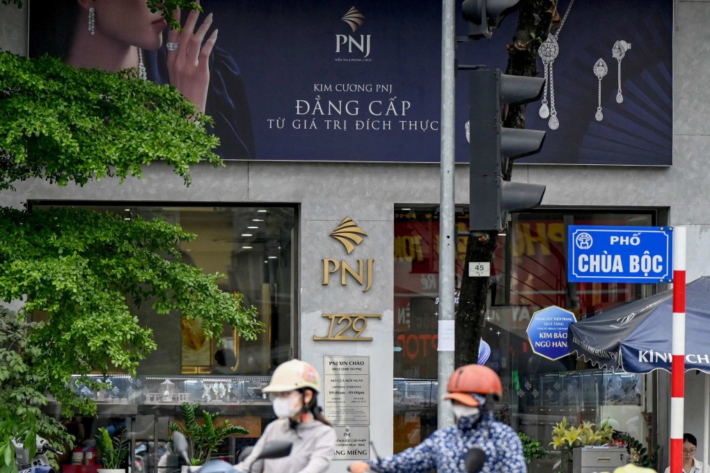 People ride past a Phu Nhuan Jewellery store in Hanoi on July 15, 2026. Photo: AFP