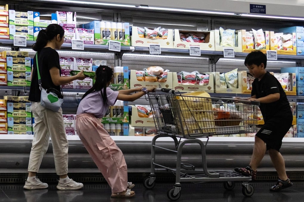 A woman and two children shop in front of a refrigerated cheese shelf at a supermarket in Beijing on July 10. Photo: Reuters