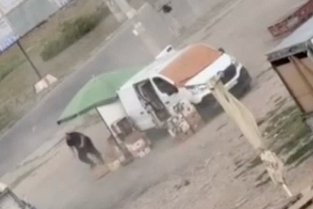 A drone circles over a man at a market in Kherson, Ukraine, before detonating nearby, in footage released on Tuesday. Photo: Kherson Regional Military Administration via Reuters