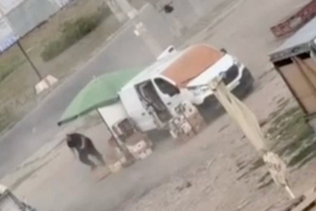 A drone circles over a man at a market in Kherson, Ukraine, before detonating nearby, in footage released on Tuesday. Photo: Kherson Regional Military Administration via Reuters