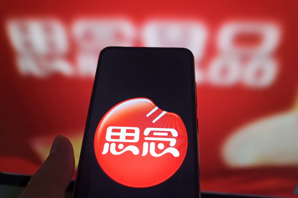 An internet user views the Synear Food webpage on his computer in the background with the company logo displayed on his phone. The company has been blacklisted by Washington for allegedly using forced labour. Photo: Getty Images