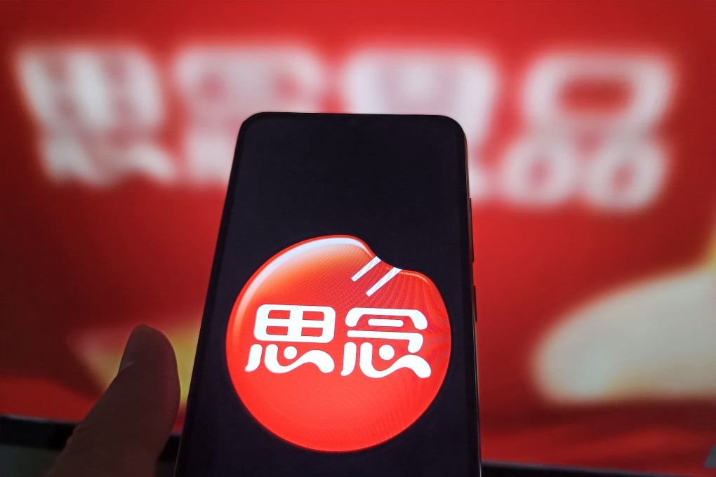 An internet user views the Synear Food webpage on his computer in the background with the company logo displayed on his phone. The company has been blacklisted by Washington for allegedly using forced labour. Photo: Getty Images