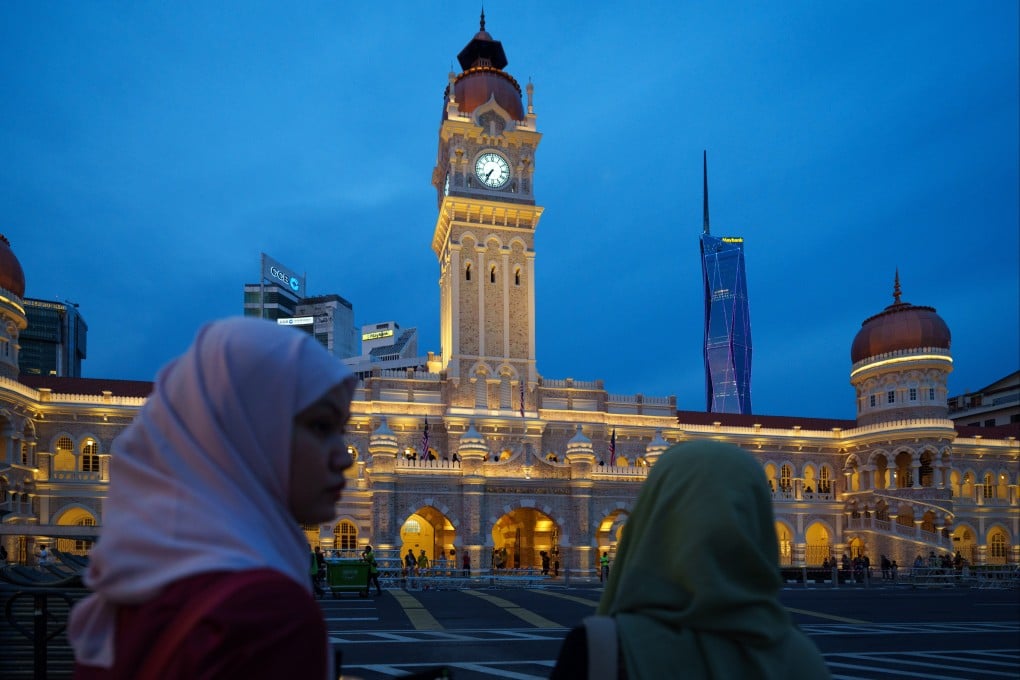 Women walk past the illuminated Sultan Abdul Samad Building in Kuala Lumpur, Malaysia, on July 26. In recent weeks, Prime Minister Anwar Ibrahim’s multi-ethnic governing coalition has suffered two consecutive defeats in state elections following campaigns dominated by racial and religious appeals. Photo: AP