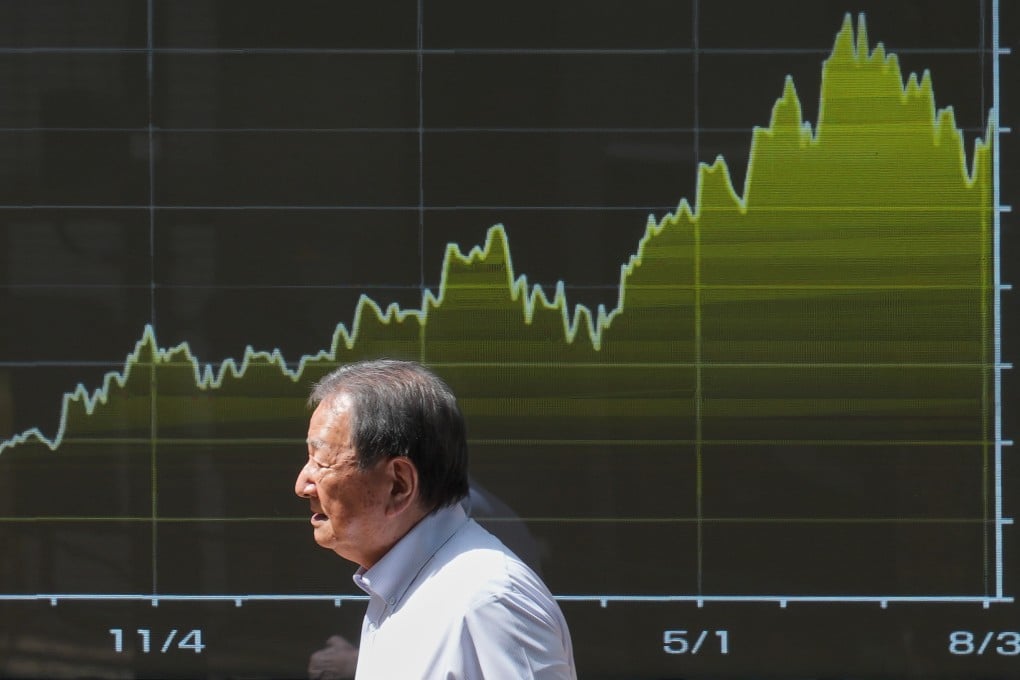 A person walks past an electronic board showing Japan’s Nikkei index chart in Tokyo on August 6. At a time when the US is the main source of volatility in global markets, Washington’s participation in the Japanese currency intervention adds another layer of uncertainty. Photo: AP