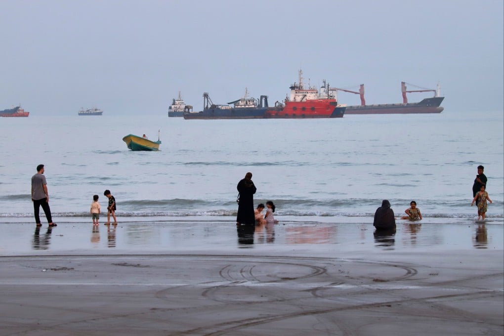 People spend time at a beach as commercial vessels are anchored in the Strait of Hormuz off Bandar Abbas, Iran, on Wednesday. Photo: ISNA via AP