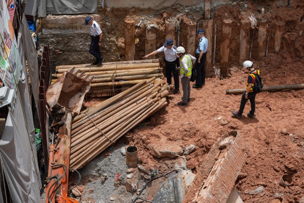 Police and Labour Department officers investigate an accident after an excavator fell on its side, killing a 41-year-old man, at a construction site in Ho Man Tin on June 29. Photo: Jelly Tse
