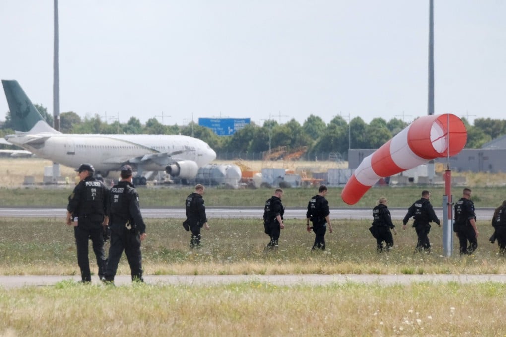 Police officers walk across a field on the grounds of Leipzig/Halle Airport in Germany on Friday. Photo: dpa