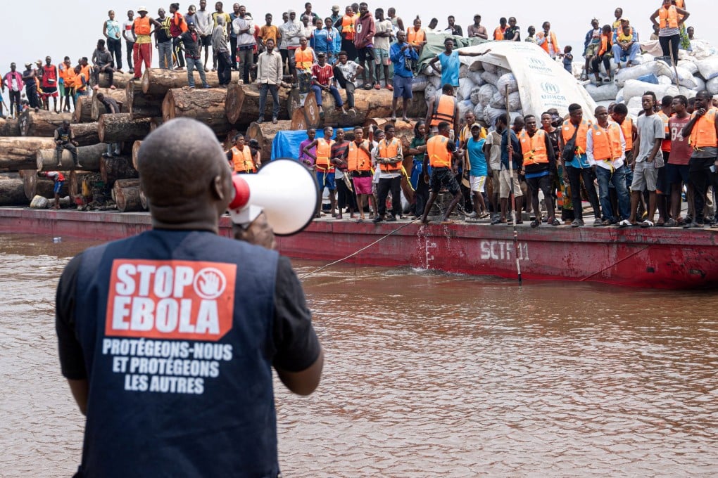 A volunteer uses a megaphone to make announcements while intercepting a passenger boat near Kinshasa, DR Congo, in an image released on Wednesday. Photo: International Organization For Migration via Reuters