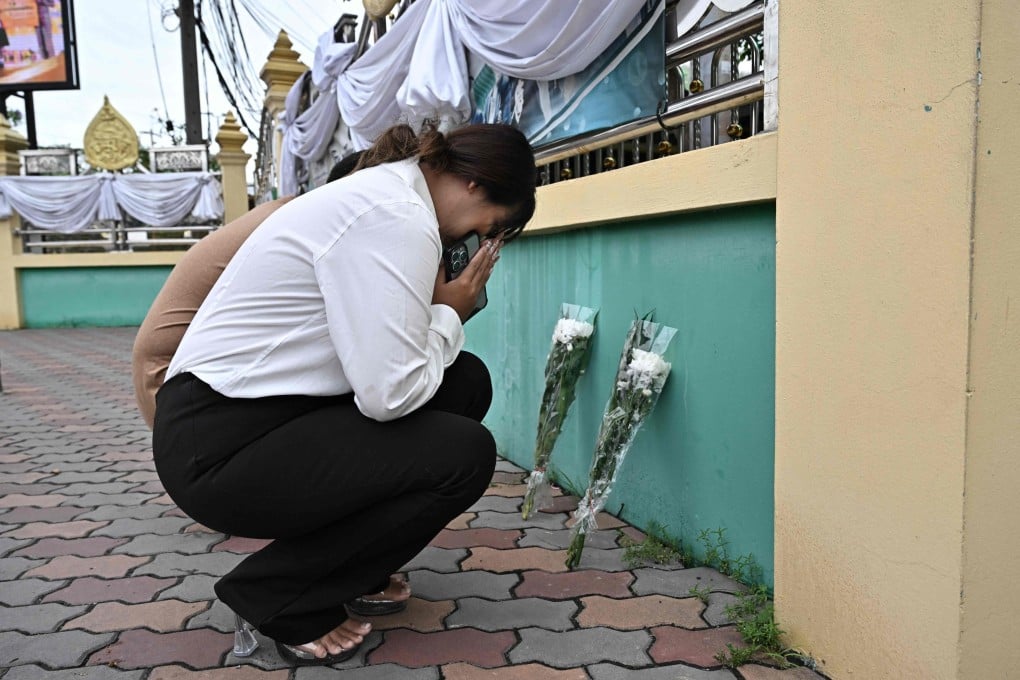 People leave flowers outside Debsirin Nonthaburi secondary school on Saturday, the day after a 14-year old pupil went on the rampage with a gun. Photo: AFP