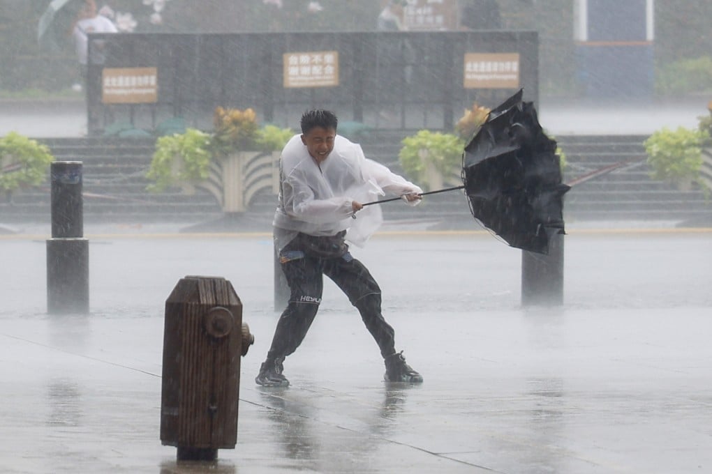 A Shanghai resident battles the winds and rain in the city. Photo: Xinhua