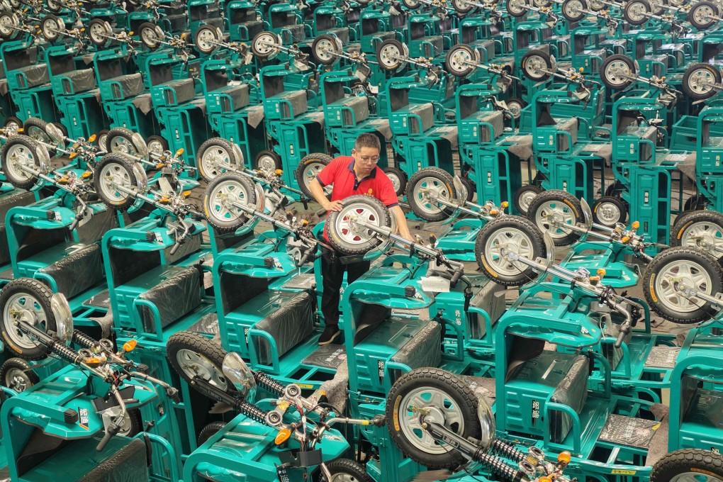 A staff member examines electric tricycles before shipment in China’s Shandong province on July 30, 2026. Photo: AFP